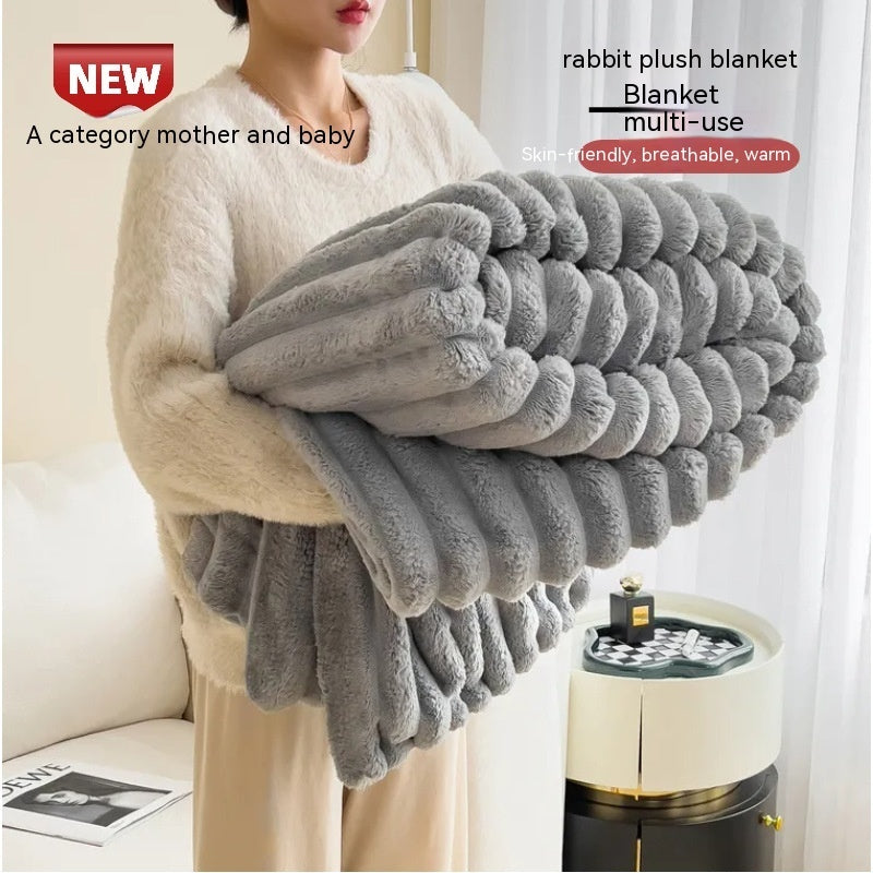 Person holding a folded gray bubble-textured faux-fur blanket